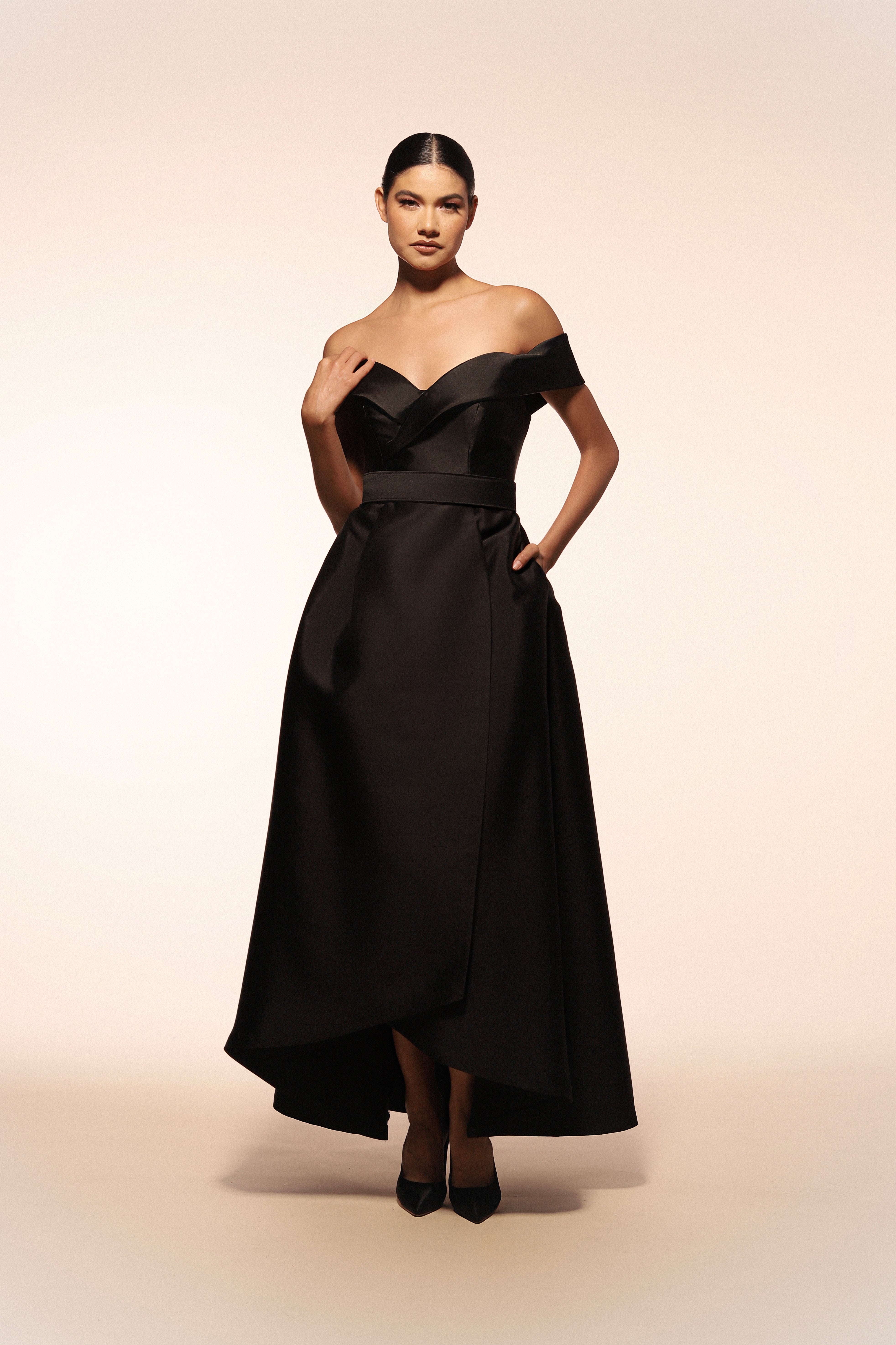 Vestido de gala Benito Santos color negro con escote barco y falda envolvente.