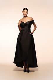 Vestido de gala Benito Santos color negro con escote barco y falda envolvente.