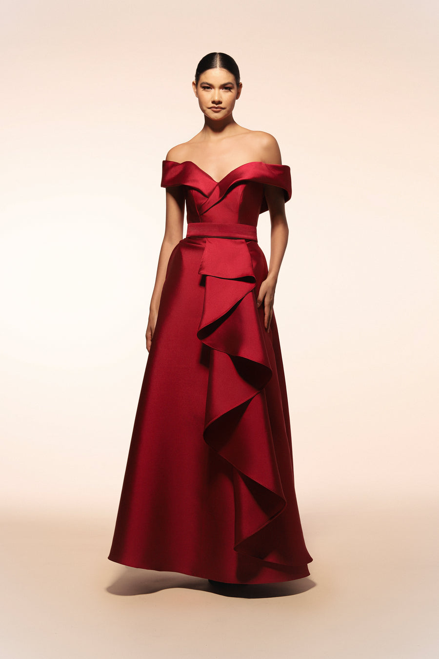 Vestido de gala Benito Santos color tinto con escote barco y falda de línea A con detalle de olanes verticales.