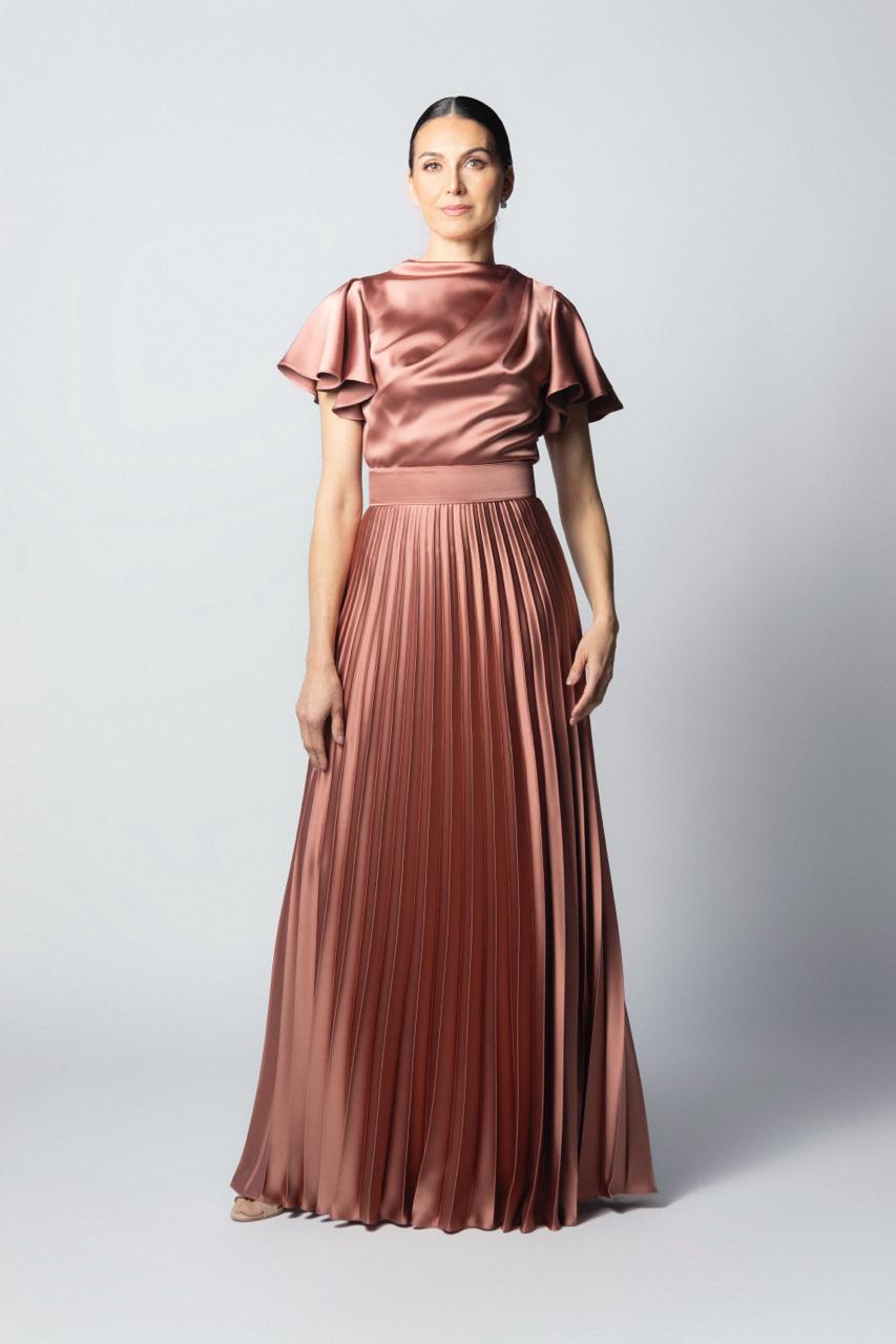 Vestido largo de fiesta en satín plisado color rosa bronce, con cuello alto, cintura marcada y mangas cortas acampanadas.