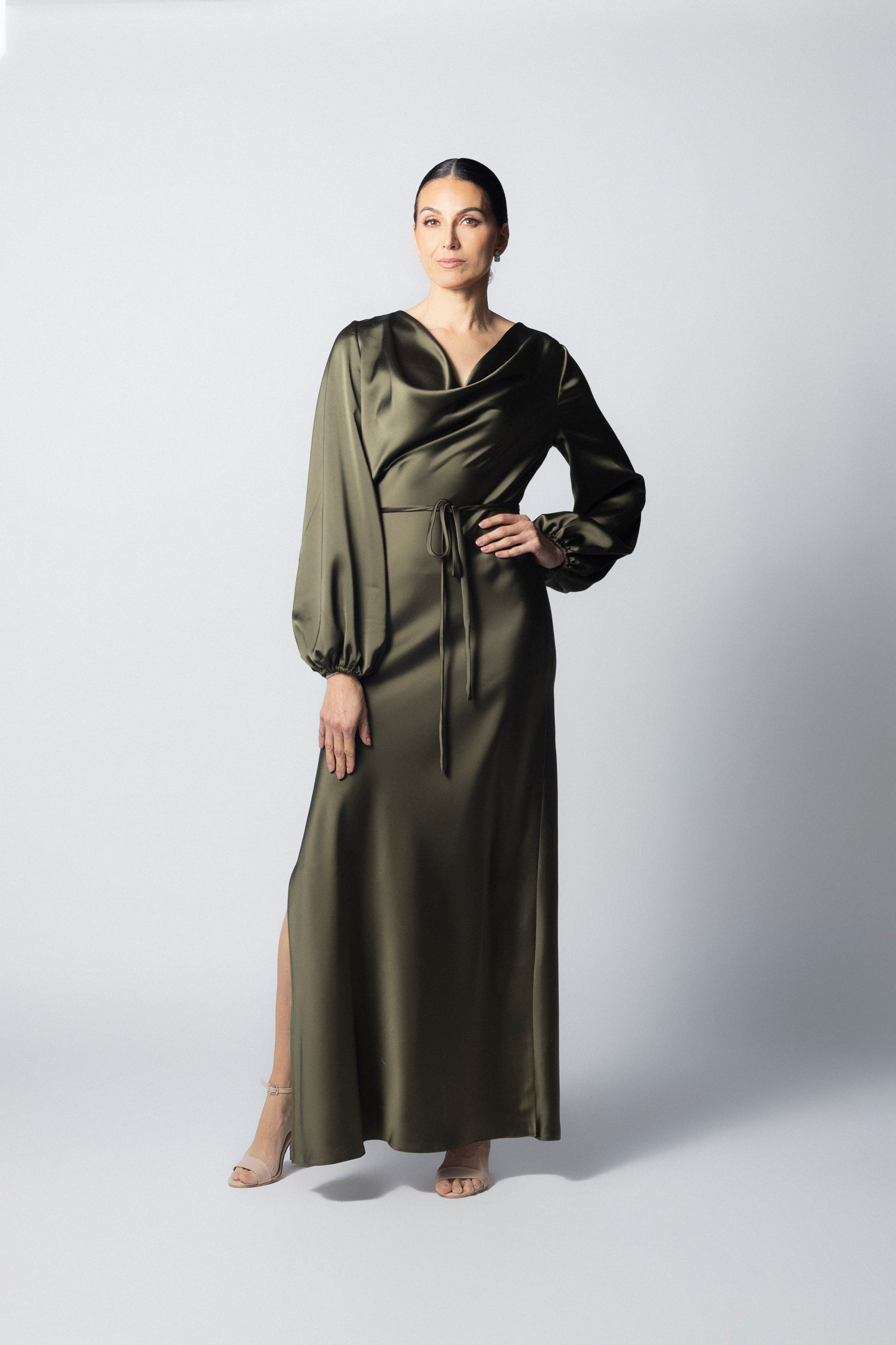 Vestido maxi de satín color olivo con cuello drapeado, mangas largas abullonadas y apertura lateral en la pierna.